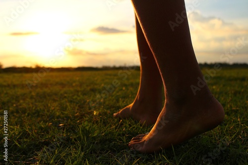 The beauty of the meadows and golden yellow skies in the evening, the children strolling on the lawn in low light, filmed as blurred images.