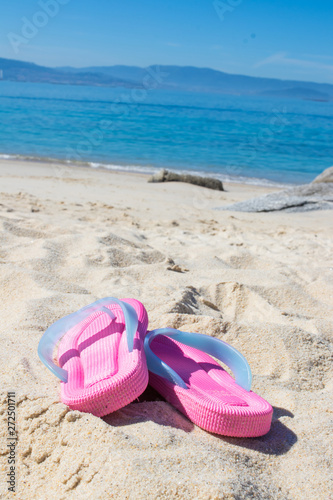 sandals in the sand of the beach, summer and holidays
