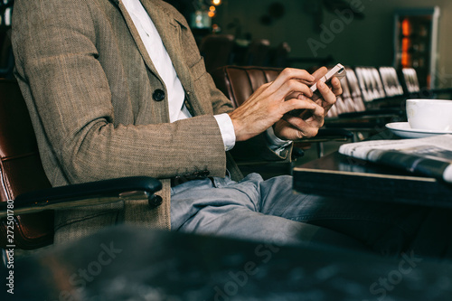 Unrecognizable Well-Dressed Man Typing on Cellphone photo