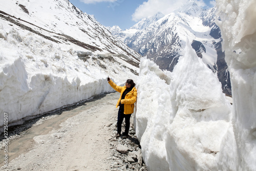 Woman taking selfie in high altitude mountain with snowwalls photo