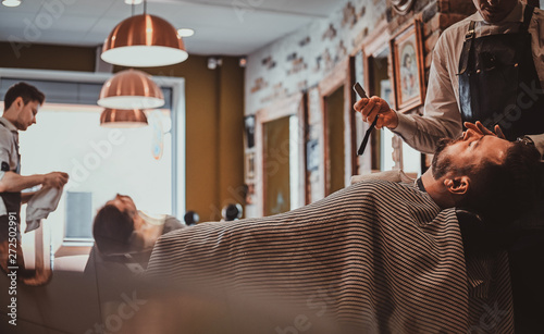 Attractive relaxed man just got great service from talanted trendy barber. photo