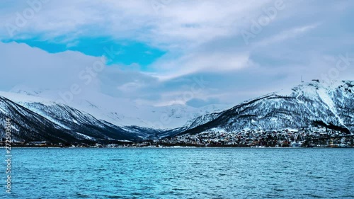 Tromso, Norway. Time-lapse during the cloudy day of famous north town Tromso, Norway. View of the fjord with houses and mountains, cloudy blue sky photo