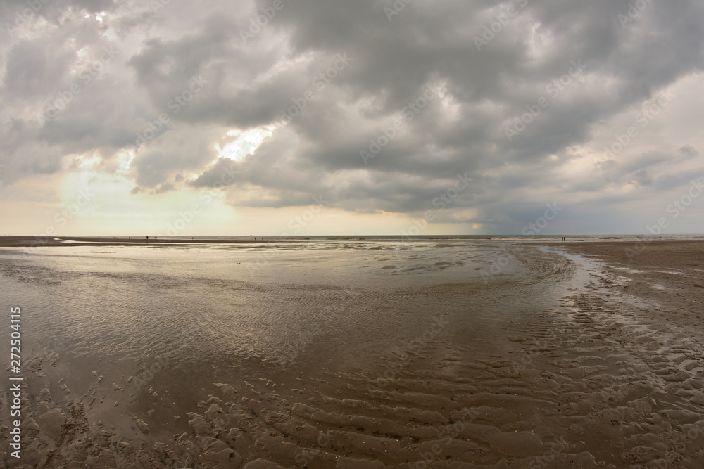 Plażą nad morzem w pochmurny dzień pod niebem z chmurami. Plażą nad morzem w pochmurny dzień pod niebem z chmurami.