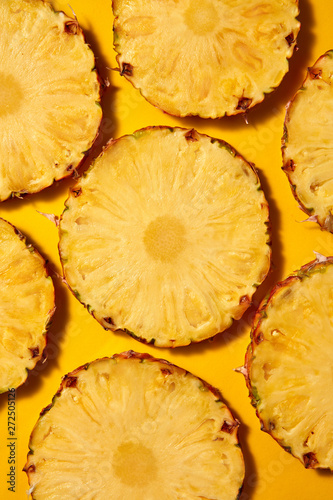 Flat lay background of round slices of juicy ripe pineapple on a photo