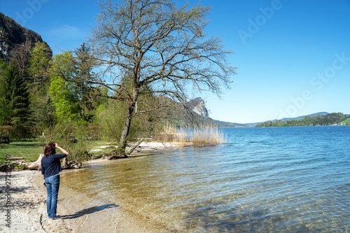 Junge Frau steht an einem See im Salzburger Land