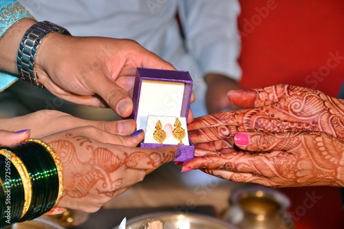 Maharashtrian Wedding Ritual - Seeman Puja - Grooms parents gift a gold earrings to Bride during Vadhu Puja photo