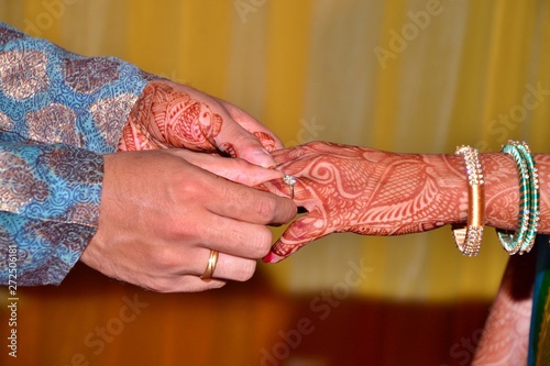 Maharashtrian Wedding Ritual - Sakharpuda (Engagement) ritual - An Indian bride and groom exchanging rings, hands  together during a Hindu ring ceremany photo
