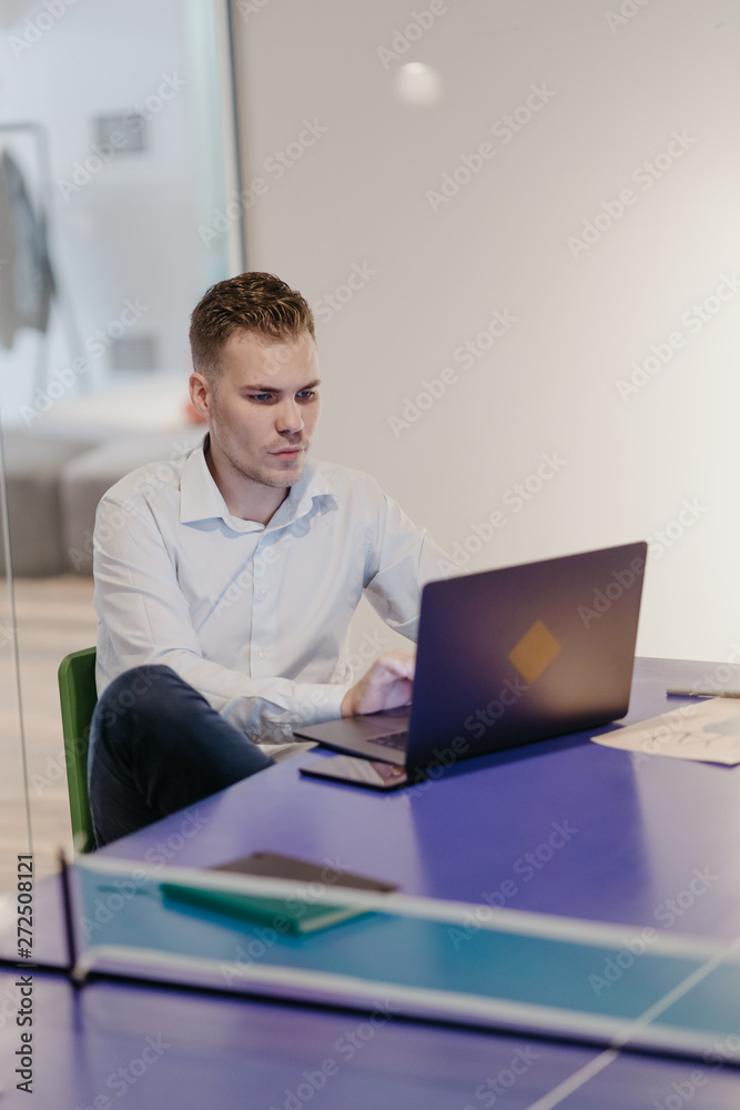 Business man working in the co-working space office on his laptop Business man working in the co-working space office on his laptop