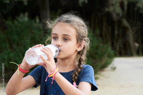 Kid hydrates with water at the park.