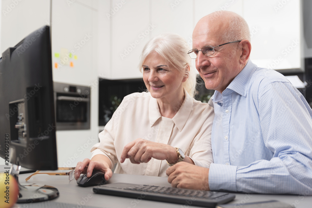 Happy elder couple enjoy together at computer Happy elder couple enjoy together at computer