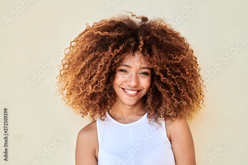 Beauty with frizzy hair smiling at camera.