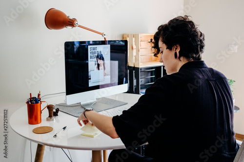 Female model using her computer at her home office photo
