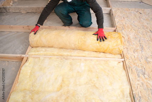 Work composed of mineral wool insulation in the floor, floor heating insulation , warm house, eco-friendly insulation, a builder at work