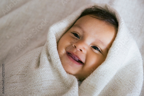 Close up of smiling baby wrapped in towel photo