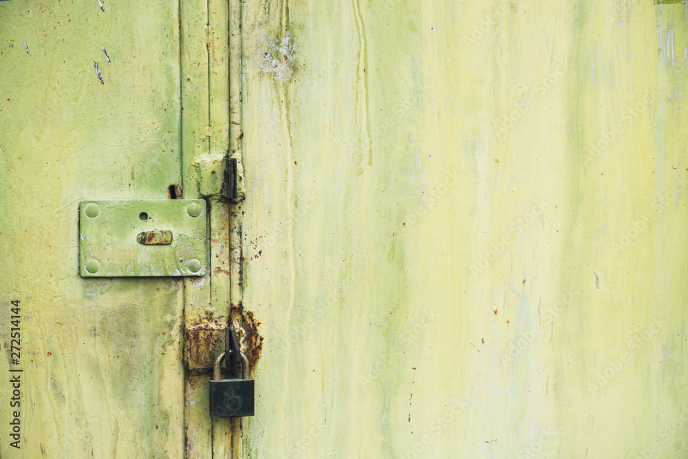 Abstract colorful wall texture and background. Close-up iron surface with yellow paint and the padlock Abstract colorful wall texture and background. Close-up iron surface with yellow paint and the padlock
