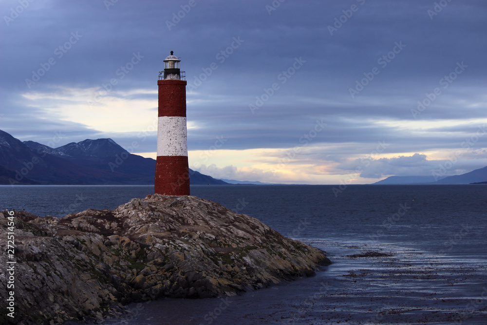 Naklejka premium Cloudy sky above a red and white lighthouse