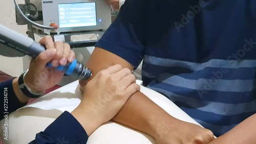 JAKARTA, Indonesia - May 23, 2019: Hand of man having a Extracorporeal shock wave therapy (ESWT) for an elbow pain in the hospital. Shot in 4k resolution photo