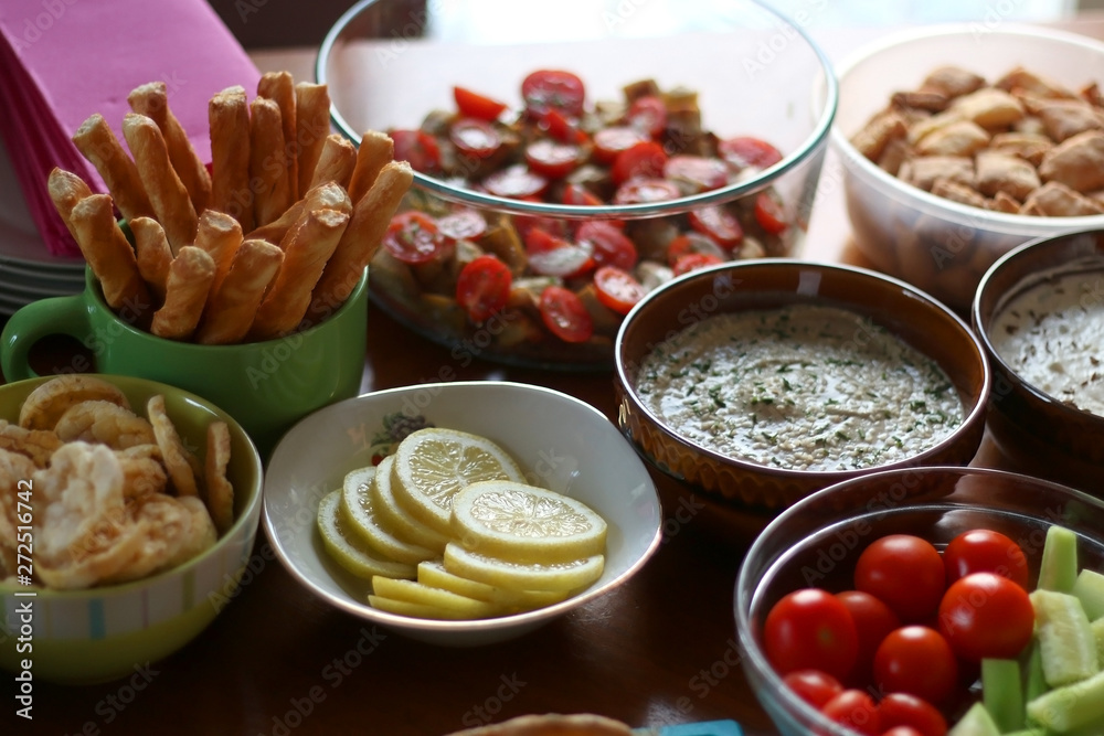 Table setting with galette, snacks, dips and salads. Selective focus. Table setting with galette, snacks, dips and salads. Selective focus.