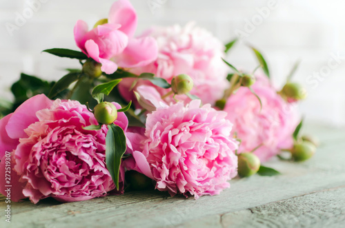 Pink peony flowers on white wooden table. womans day or wedding background.