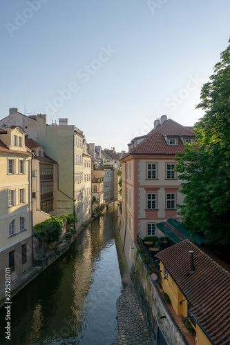 Houses standing along a water channel in the city under the morning sun