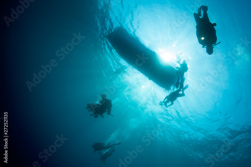 Divers descend in clear, blue depths of Komodo National Park, Indonesia. This tropical area is part of the Coral Triangle and is a popular destination for divers and snorkelers. © ead72