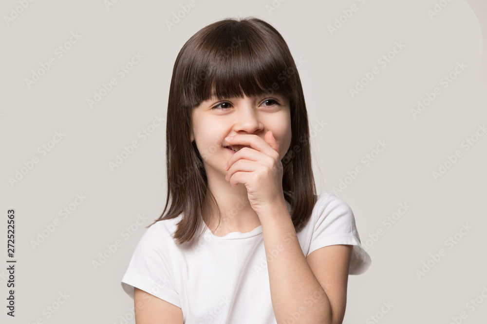 Laughing shy cute girl isolated on grey studio background Laughing shy cute girl isolated on grey studio background