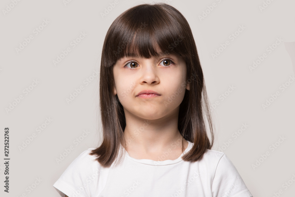 Upset little girl isolated on grey studio background Upset little girl isolated on grey studio background