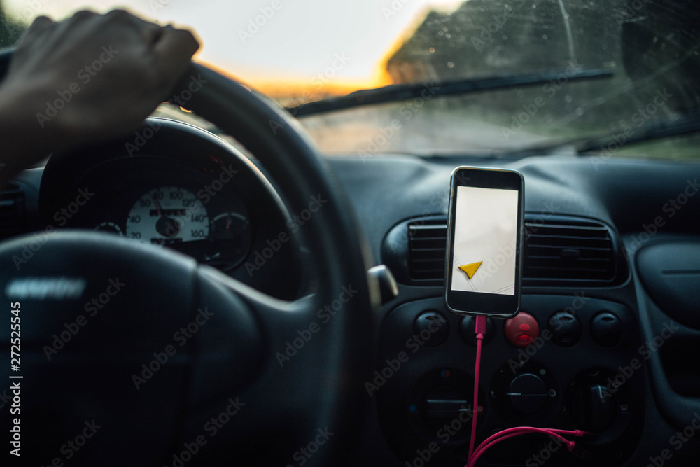 travel driving a car in the summer, the navigator in the smartphone. the driver is driving