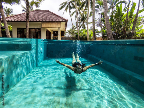 Woman swimming on the pool of a private villa in Bali