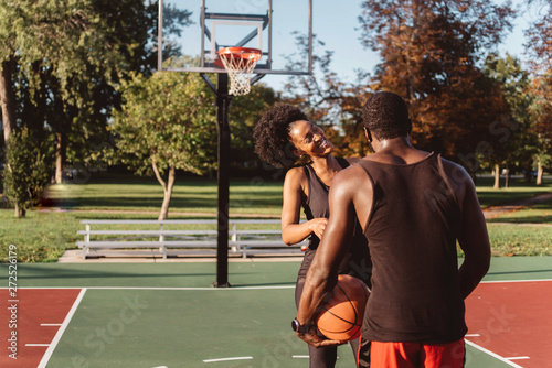 An Attractive African American Couple playing basketball on a sunny day photo