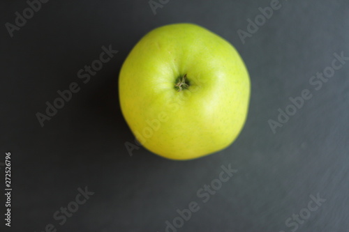 fresh raw ripe apple on black slate table background, place for text