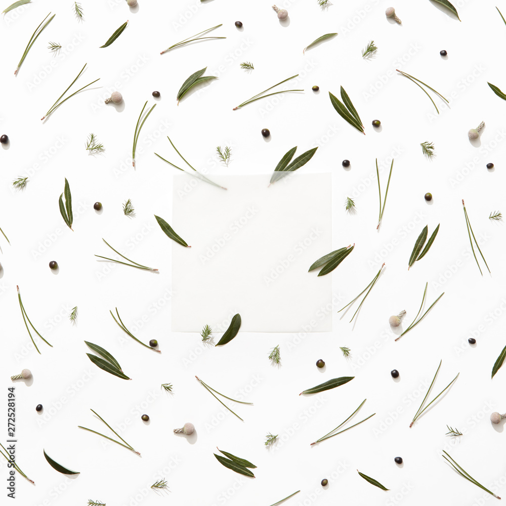 A pattern of green different leaves, black berries and a frame of kraft paper on a white background. A natural card. Flat lay A pattern of green different leaves, black berries and a frame of kraft paper on a white background. A natural card. Flat lay