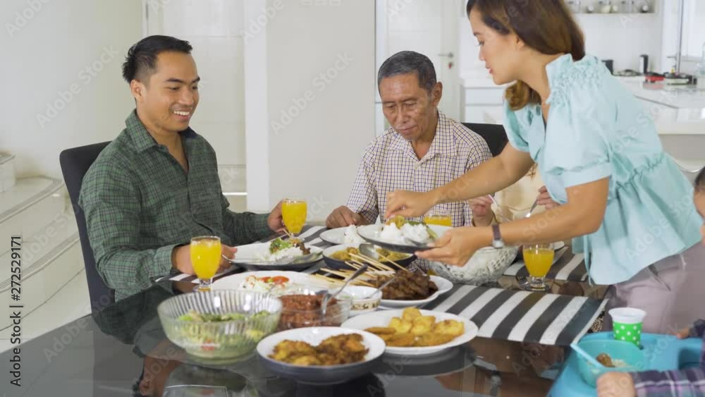 Happy family having lunch together in dining room at home. Shot in 4k resolution Happy family having lunch together in dining room at home. Shot in 4k resolution