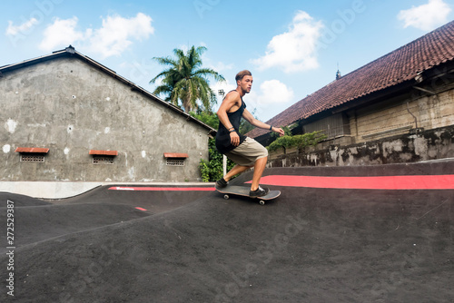 Skateboarder rides a pump track photo