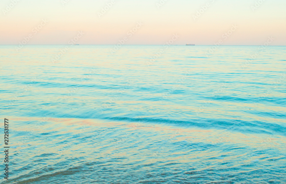 Beautifu blue sea water background. Beautiful pink color sunset on the beach.