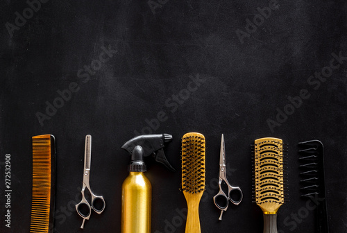 professional accessories of hairdresser with combs and sciccors on work desk black background top view copyspace