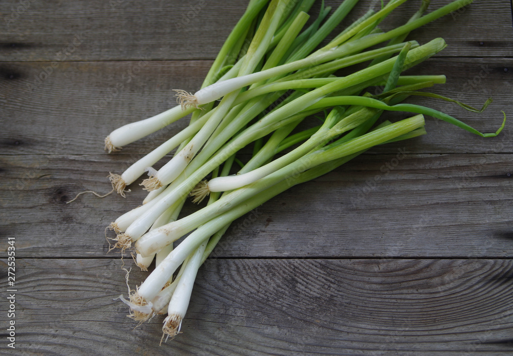 Large bunch of green onions on weathered cedar planks Large bunch of green onions on weathered cedar planks