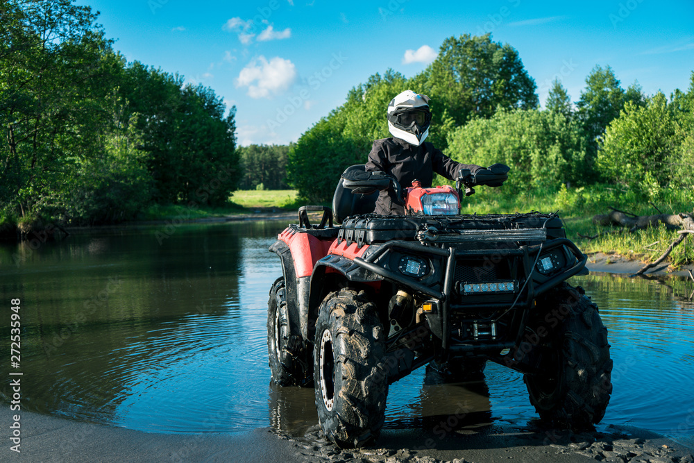 Fototapeta premium ATV in nature. Outdoor activity. Quad bike rides. Extreme sport. Forest, nature, river, field.