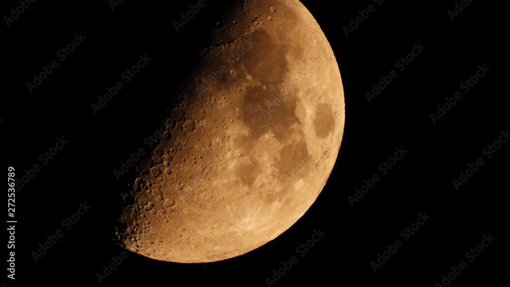 Extreme zoom tele photo of half moon as seen at night on a clear sky