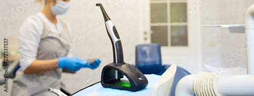 a modern photopolymerization lamp for light fillings in the dental office, on a blurred background