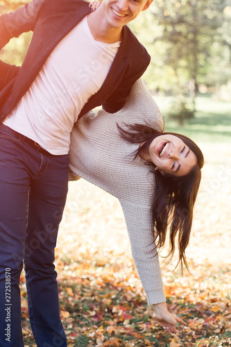 Happy young couple hugging and laughing outdoors.