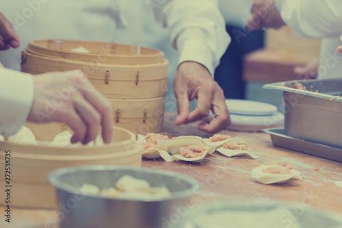 Dim Sum chefs working wrapping dumplings at famous restaurant in Taiwan.