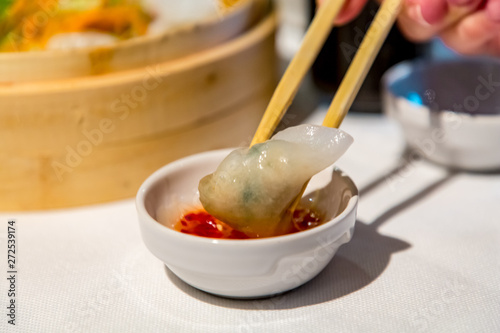 Chinese cuisine. Dim sum is held with chopsticks and dipped in sauce