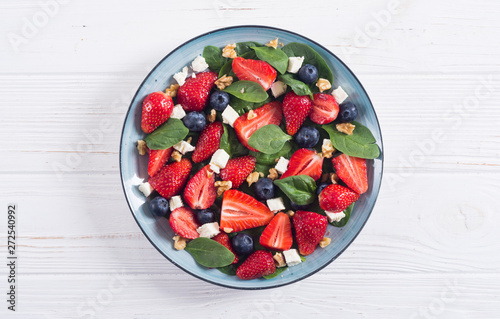 Summer Strawberry salad with spinach , cheese , nuts and blueberry