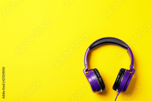 Stylish modern headphones on color background, top view. Space for text