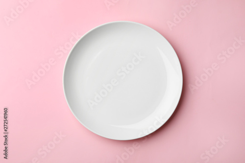 Clean empty plate on color background, top view