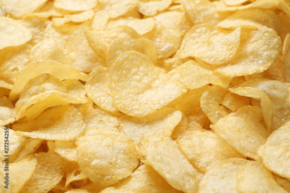 Pile of crispy potato chips as background, closeup Pile of crispy potato chips as background, closeup