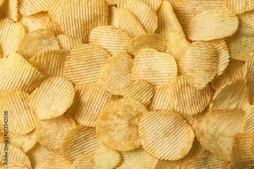 Crispy potato chips as background, top view