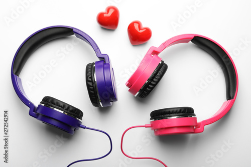 Decorative hearts and modern headphones on white background, top view