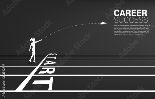 silhouette of businesswoman throw out origami paper airplane from start line on running track. Business Concept of start business and entrepreneur